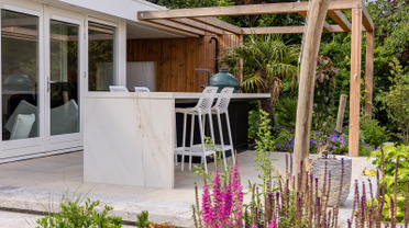 Een buitenkeuken met tuinkas